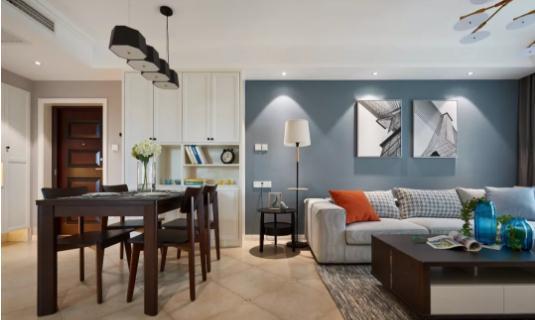客厅整体以冷色为基调,舒适的布艺沙发搭配蓝灰色背景墙,一抹橘色的